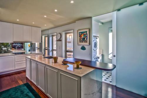 a large kitchen with white cabinets and a large island at Oscar Chalupsky Apartment in Vila do Conde