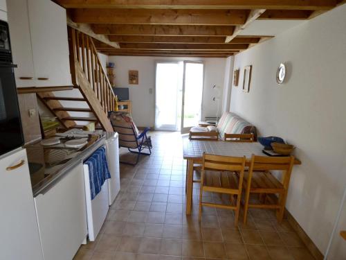 une cuisine et une salle à manger avec une table et un comptoir dans l'établissement Maison cosy pour 4 pers., à 250 m de la plage St-Jacques, Sarzeau - FR-1-639-31, à Sarzeau