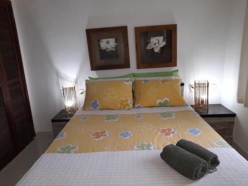 - une chambre avec un lit doté d'une couverture jaune et d'oreillers dans l'établissement Casa em Cond Geriba 400mt Praia com Espaço Gourmet, à Búzios