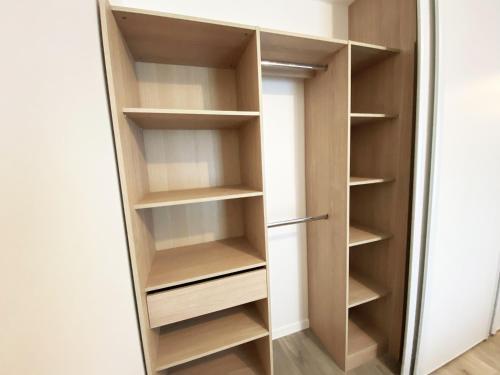 un placard avec des étagères en bois et une porte dans l'établissement Appartement neuf 2-4 pers, terrasse et jardin, à 400m de la plage du Rohaliguen - FR-1-639-35, à Sarzeau