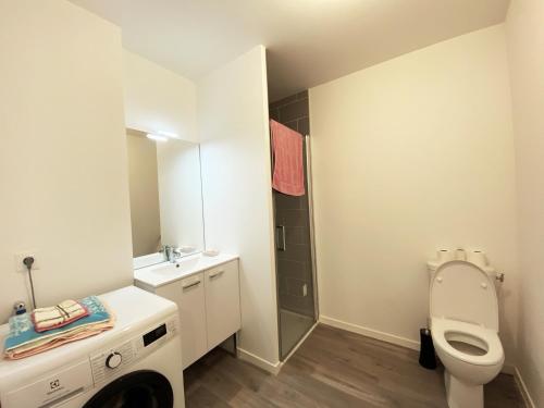 une salle de bain avec toilettes, lavabo et miroir dans l'établissement Appartement neuf 2-4 pers, terrasse et jardin, à 400m de la plage du Rohaliguen - FR-1-639-35, à Sarzeau