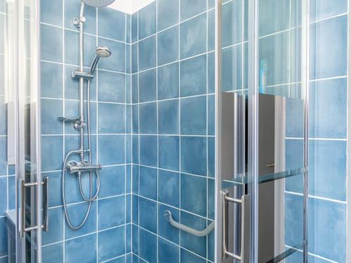 - une douche carrelée de bleu avec une porte de douche vitrée dans l'établissement Maison Individuelle T4 pour 5 pers, Proche Centre et Océan, Grand Jardin, Non Fumeur, Pas d'animaux - FR-1-521-190, à Biscarrosse