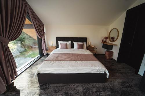 a bedroom with a large bed and a large window at Georgia Chalet in Dorna Arini