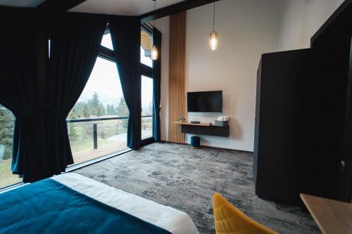 a bedroom with a bed and a large window at Georgia Chalet in Dorna Arini