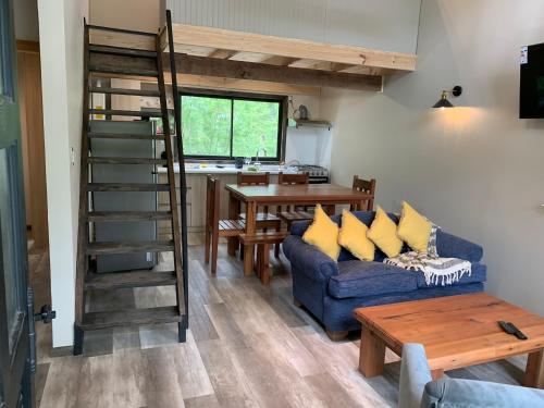 a living room with a blue couch and a table at Cabañas Alto Bosque in Pucón