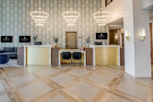 a lobby with a check in counter and chairs at Sandman Signature Saskatoon South Hotel in Saskatoon