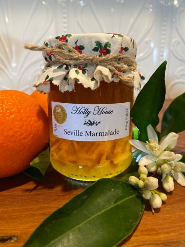 a jar of honey next to an orange and leaves at Holly House Bed & Breakfast in Moyhu