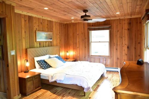 a bedroom with wooden walls and a bed in a room at Quiet and Comfy 3bed/2bath - Chalet with hot tub. in Cedar