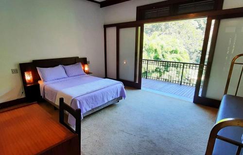 1 dormitorio con 1 cama y balcón en Canto das Águas Atibaia, en Atibaia