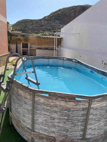 a large swimming pool with two chairs around it at Casa Luz De Alba in Calabardina