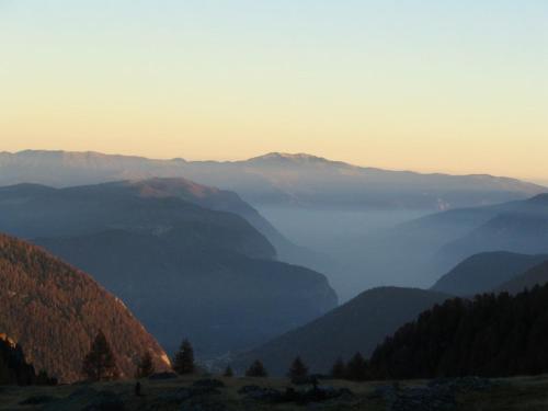 a view of a misty valley in the mountains at Baita Figliezzi in Castello Tesino