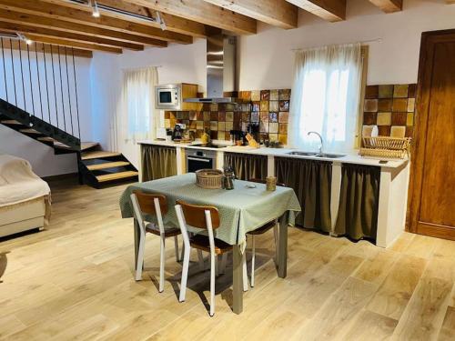 eine Küche mit einem Tisch und Stühlen im Zimmer in der Unterkunft MASIA FINCA MAS ROIG in Camarles