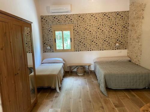een kamer met 2 bedden en een raam bij MASIA FINCA MAS ROIG in Camarles
