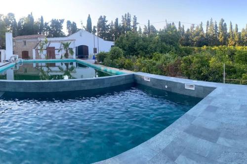 uma piscina com água azul num quintal em MASIA FINCA MAS ROIG em Camarles