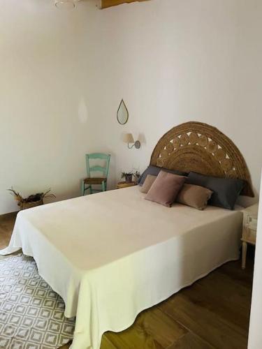sypialnia z dużym białym łóżkiem z poduszkami w obiekcie MASIA FINCA MAS ROIG w mieście Camarles