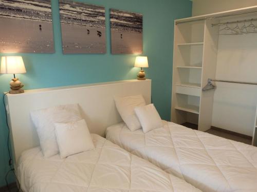 a bedroom with a white bed with two pillows at Appartement 2-6 pers, 2 ch, balcon, piscine, accès plage, parking - FR-1-194-234 in La Tranche-sur-Mer