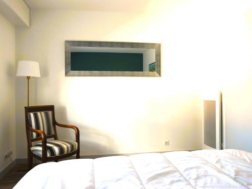 - une chambre avec un lit, une chaise et une télévision dans l'établissement Appartement 1 chambre, garage, accès direct plage - FR-1-197-527, à Les Sables-dʼOlonne