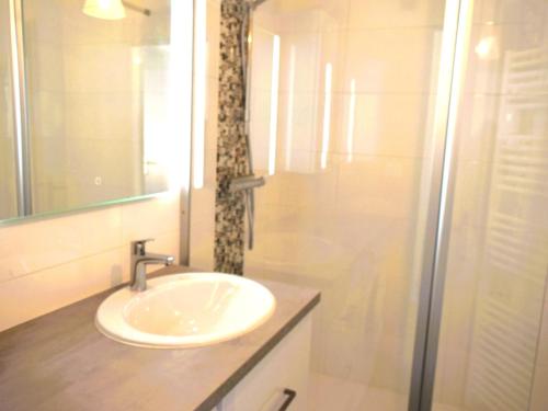 une salle de bain blanche avec un lavabo et une douche dans l'établissement Appartement 1 chambre, garage, accès direct plage - FR-1-197-527, à Les Sables-dʼOlonne