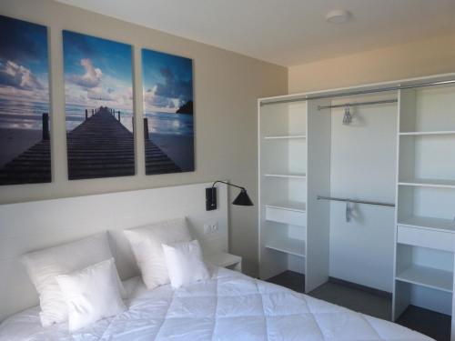 1 dormitorio con 1 cama blanca y 3 cuadros en la pared en Appartement La Tranche-sur-Mer, 3 pièces, 6 personnes - FR-1-194-232, en La Tranche-sur-Mer