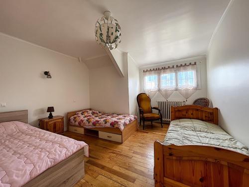 een slaapkamer met 2 bedden, een stoel en een kroonluchter bij Maison Donville-les-Bains, 4 pièces, 7 personnes - FR-1-361-425 in Donville-les-Bains
