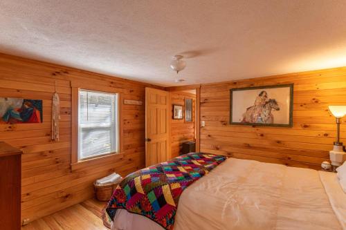 a bedroom with wooden walls and a bed in a room at Hidden Cabin on Old Field Creek in Fleetwood