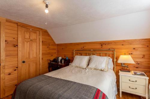 a bedroom with a bed and a wooden wall at Hidden Cabin on Old Field Creek in Fleetwood