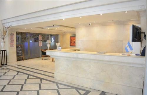 eine Lobby mit einer Bar mit einem TV an der Wand in der Unterkunft MZA Departamentos in Mendoza