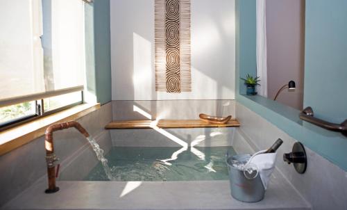 Azure Palm Hot Springs في ديزيرت هوت سبرينغز: حمام مع حوض به صنبور