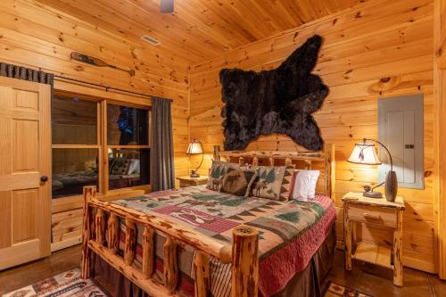 um quarto com uma cama num chalé de madeira em Bearadise at Blue Ridge em West Jefferson