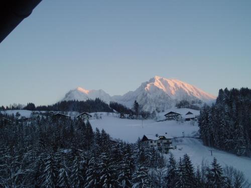 a snow covered mountain with a house in the foreground at Ausflugshotel Huttersberg in Kirchdorf an der Krems