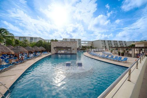 a swimming pool at a resort with lounge chairs at Grand Sirenis Riviera Maya Resort & Spa All Inclusive in Akumal
