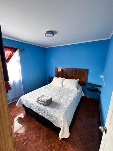 1 dormitorio azul con 1 cama con pared azul en HOSTAL APANANTOR 1 en San Pedro de Atacama