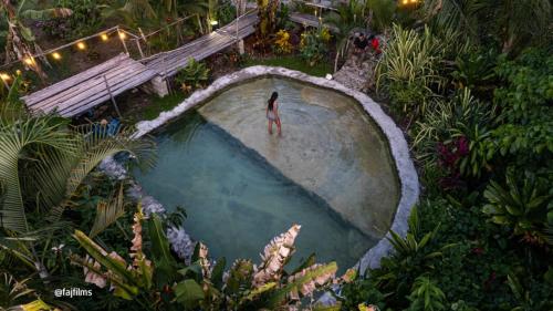 uma pessoa de pé numa piscina vazia num jardim em Samana Ecolodge em El Limón