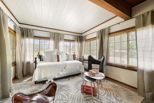 a bedroom with a bed and a chair and windows at The Hemingway in Bentonville