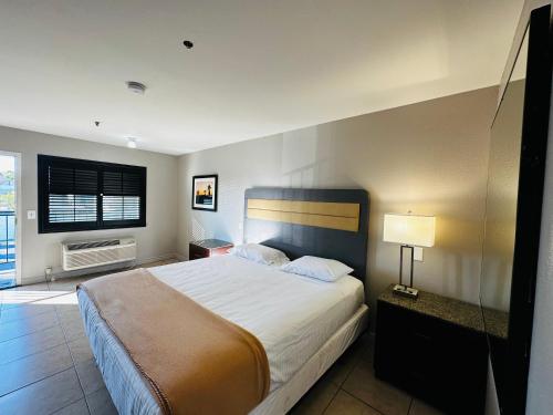 a bedroom with a large bed and a window at Casa Blanca Express & Suites Cypress Buena Park - Anaheim Area in Cypress