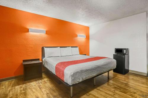 uma cama num quarto com uma parede laranja em Motel 6-Clovis, NM em Clovis