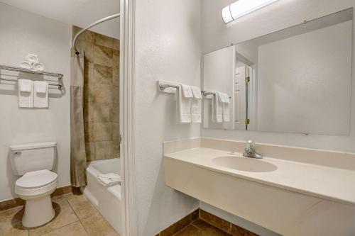 y baño con lavabo, aseo y espejo. en Motel 6-Clovis, NM, en Clovis