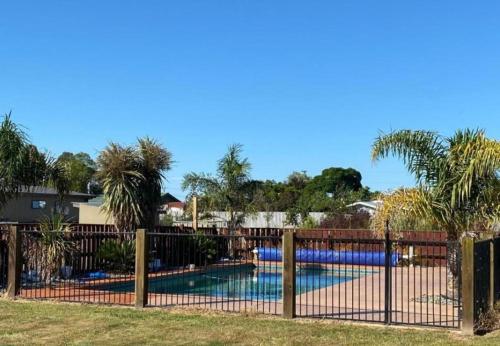 a swimming pool behind a fence with a swimming pool at Country Retreats On Ranzau 4 in Hope
