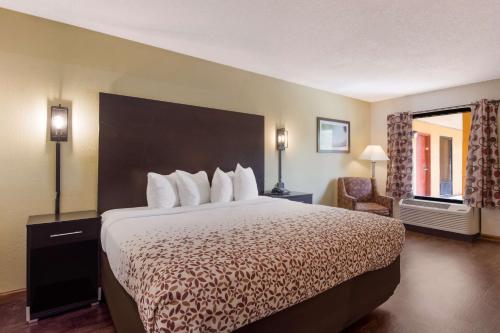 een hotelkamer met een groot bed en een stoel bij SureStay Hotel by Best Western St Pete Clearwater Airport in Clearwater