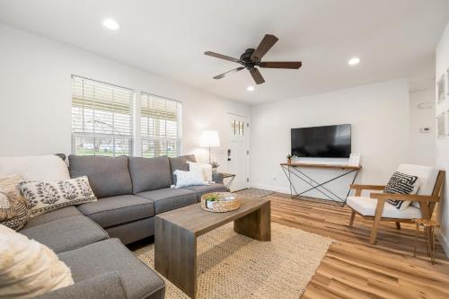 a living room with a couch and a ceiling fan at B Street Bungalow in Bentonville