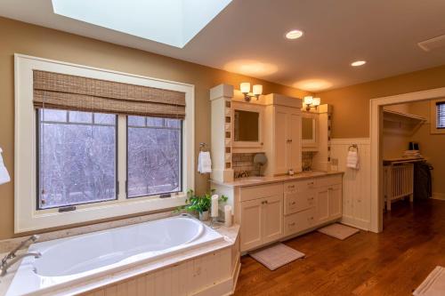 een grote badkamer met een groot bad en een raam bij Skytop Retreat in Sugar Mountain
