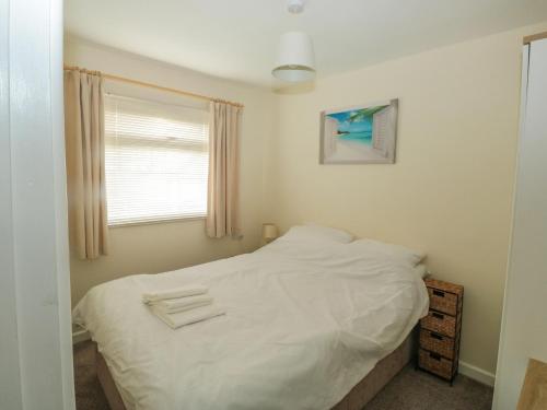 ein Schlafzimmer mit einem weißen Bett und einem Fenster in der Unterkunft The Bolthole in Dartmouth