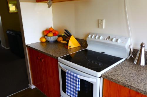 a kitchen with a stove and a bowl of fruit at The Parklet in Patangata