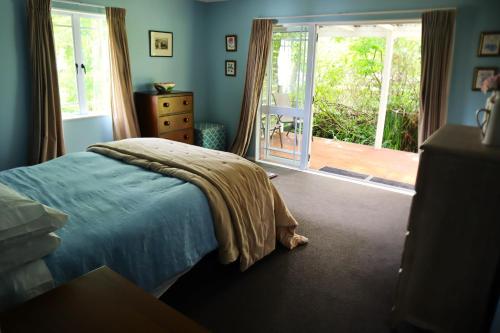 a bedroom with a bed and a sliding glass door at The Parklet in Patangata