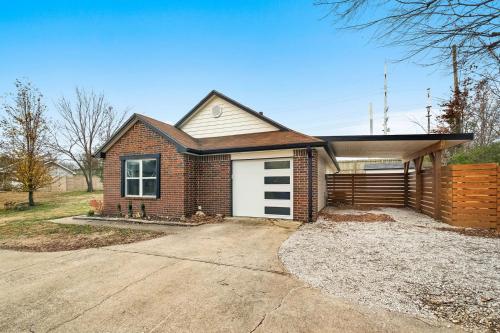 a brick house with a white garage at OZK Trail House in Bentonville