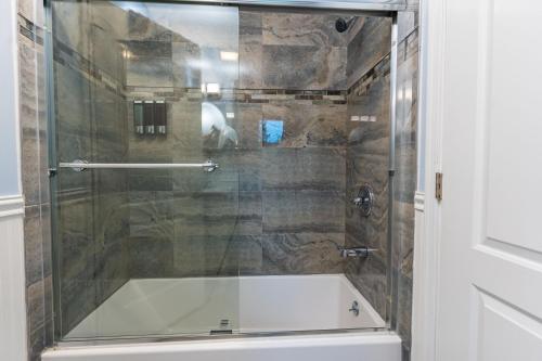 y baño con ducha de cristal y bañera. en Poconos Home with Marshall's Creek Views - Nearby Ski, HUGE Private 6 Bedroom Home!, en East Stroudsburg