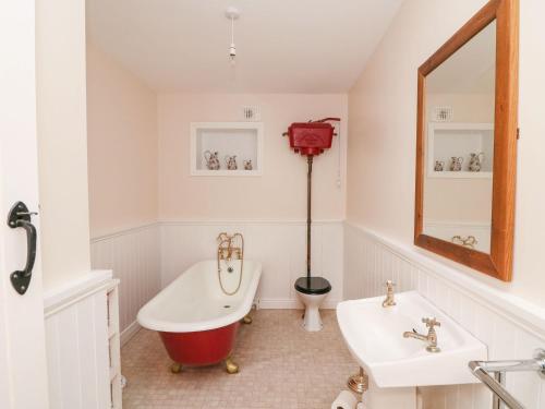 uma casa de banho com uma banheira e um lavatório em Coffeys em Ballymacarbry