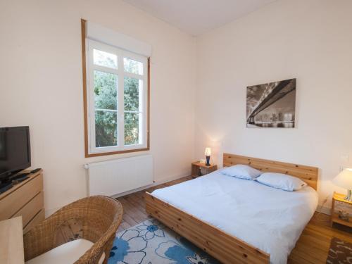 1 dormitorio con 1 cama, TV y ventana en Villa Soulac-sur-Mer, 9 pièces, 11 personnes - FR-1-648-42, en Soulac-sur-Mer