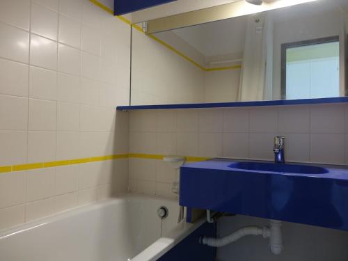 La salle de bains est pourvue d'un lavabo bleu et d'une baignoire. dans l'établissement Appartement pour 5 pers. avec terrasse et accès piscine à Arzon - FR-1-639-17, à Arzon