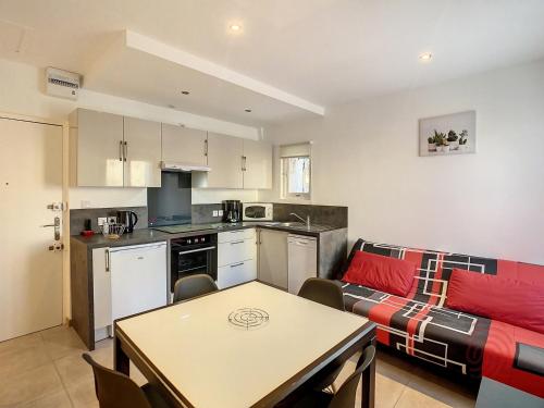 une cuisine et un salon avec une table et un canapé dans l'établissement Charmant F2 avec Wifi à 150m des Thermes et centre-ville de Lamalou-les-Bains - FR-1-451-149, à Lamalou-les-Bains